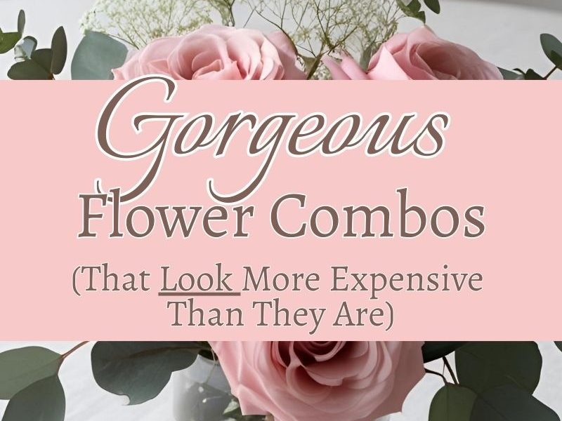 floral arrangement consisting of pink roses, baby's breath and eucalyptus in a glass vase sitting on a table with white linen tablecloth